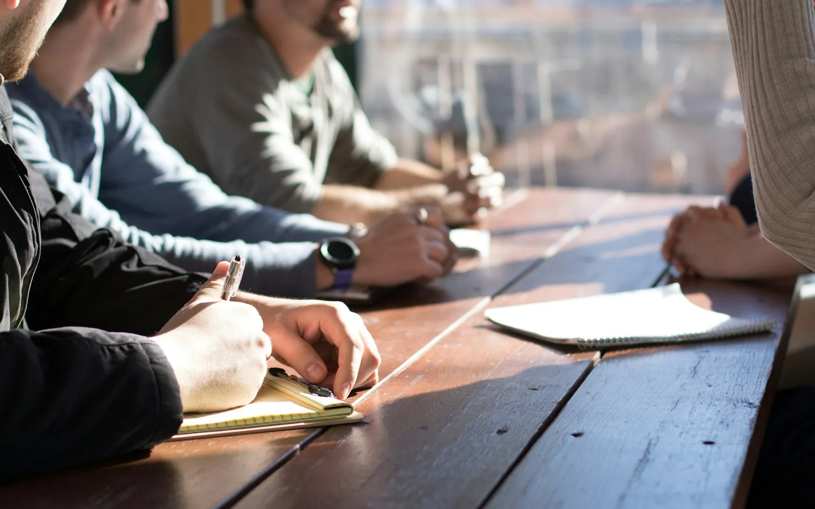 Two people comparing notes around a wooden table during a planning session